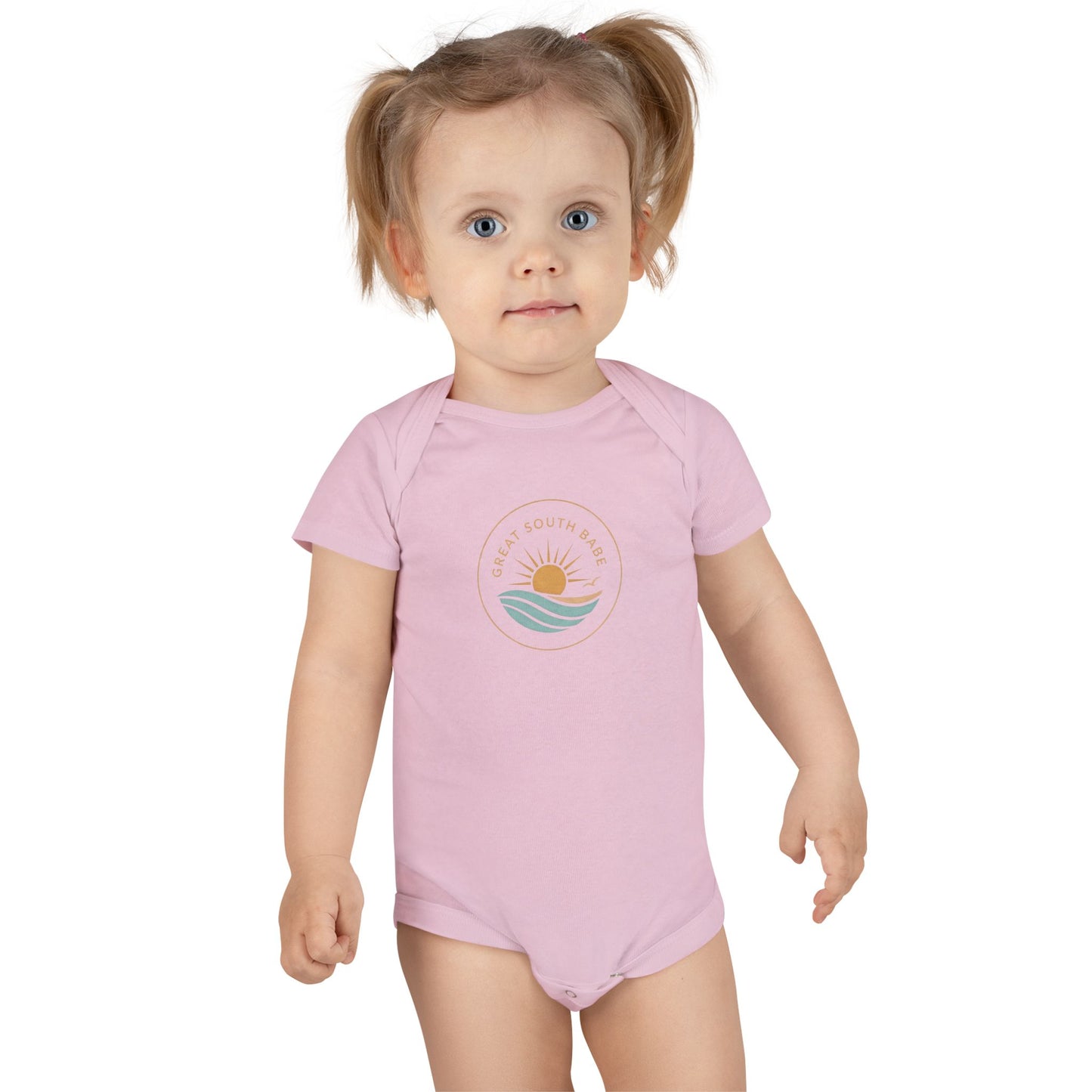 Toddler girl wearing light pink Great South Babe onesie with sun and waves logo
