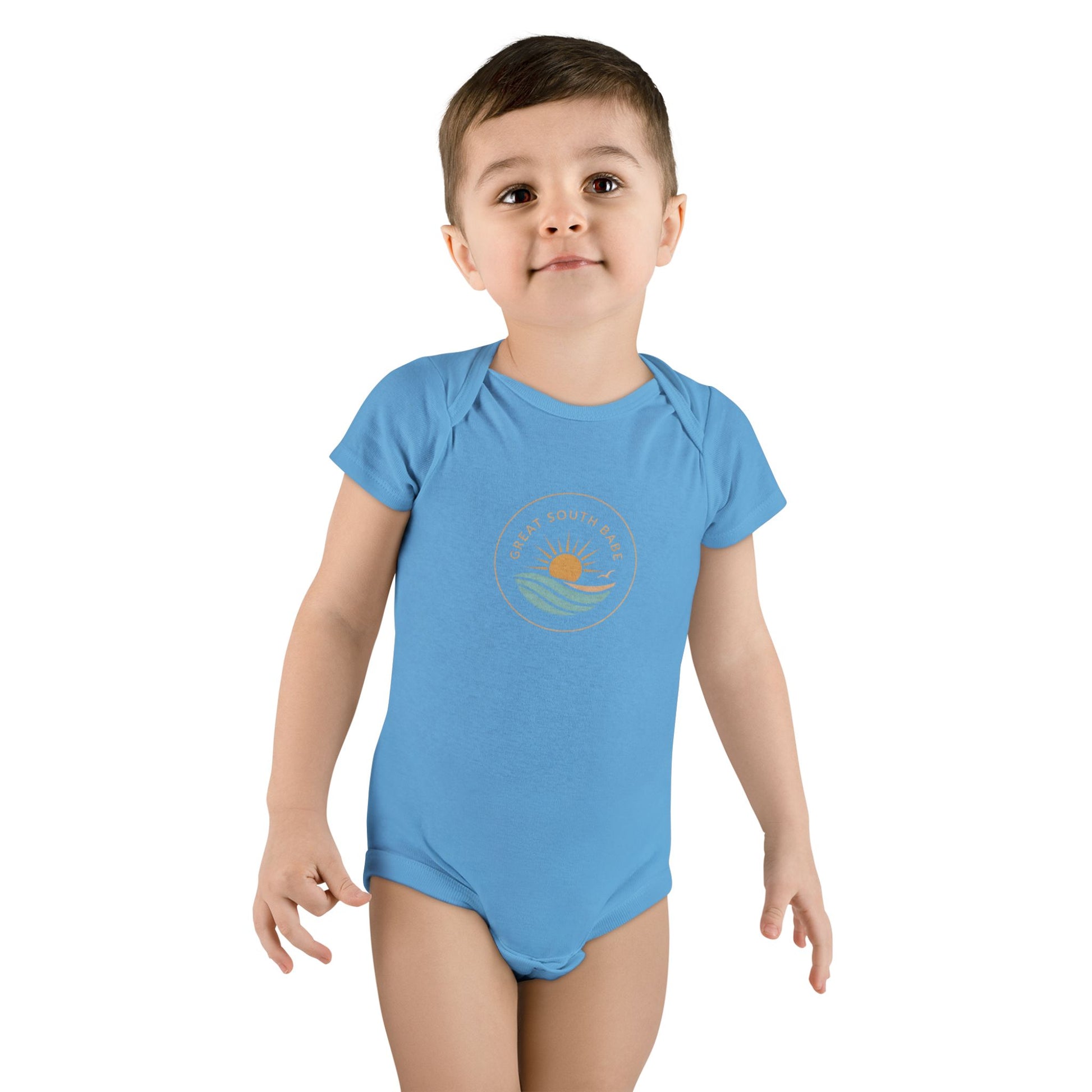 Toddler boy wearing blue Great South Babe onesie with sun and waves logo