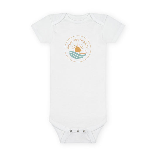 Great South Babe onesie in white with sun and waves logo, flat lay