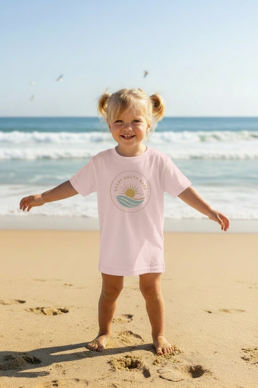 Toddler girl wearing light pink Great South Babe toddler tee on the beach